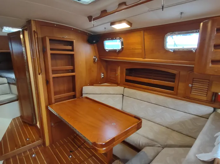 Wu Wei Yacht Photos Pics Interior of 1997 Pacific Seacraft 37 sailboat with wooden furnishings and cozy seating area.