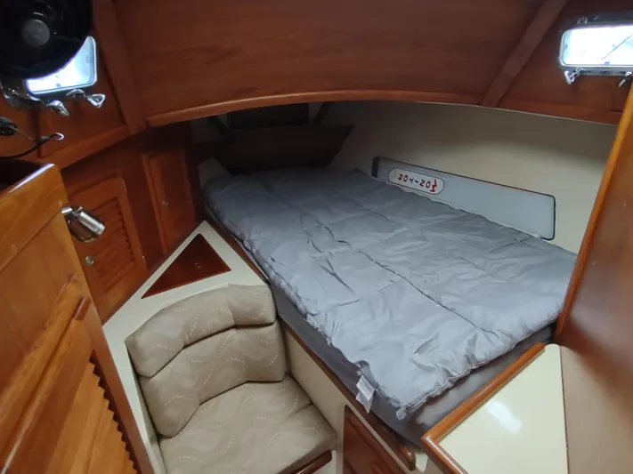 Wu Wei Yacht Photos Pics Cozy cabin interior of 1997 Pacific Seacraft 37 sailboat with bed and seating area.