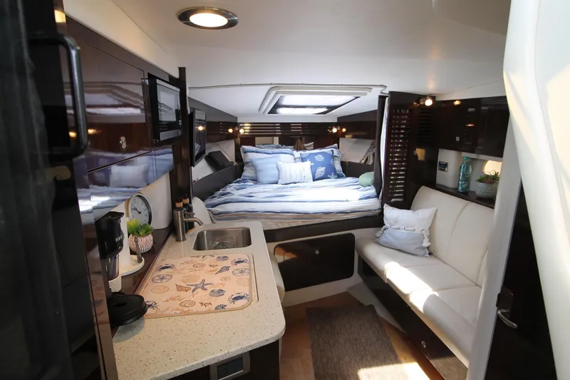  Yacht Photos Pics Luxurious interior of 2015 Sea Ray Sundancer 310 yacht with cozy bed and kitchenette.