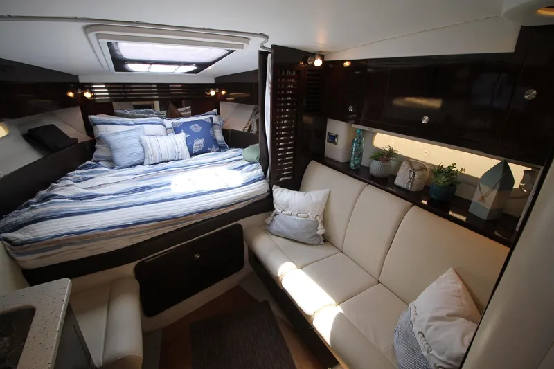  Yacht Photos Pics Luxurious interior of 2015 Sea Ray Sundancer 310 with cozy bed and elegant seating area.