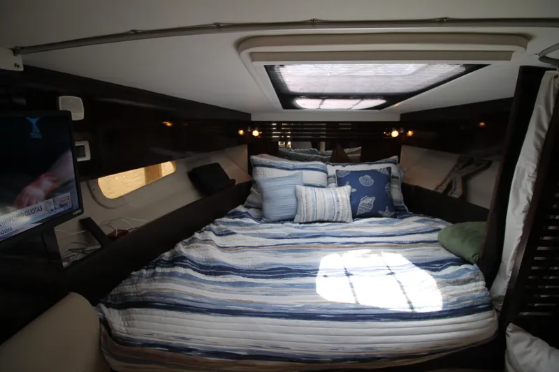  Yacht Photos Pics Luxurious cabin interior of 2015 Sea Ray Sundancer 310 with cozy bedding and natural light.