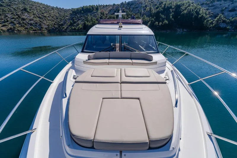 Whiskey Yacht Photos Pics Luxurious 2021 Princess F55 yacht on serene water, featuring spacious sunbathing deck.