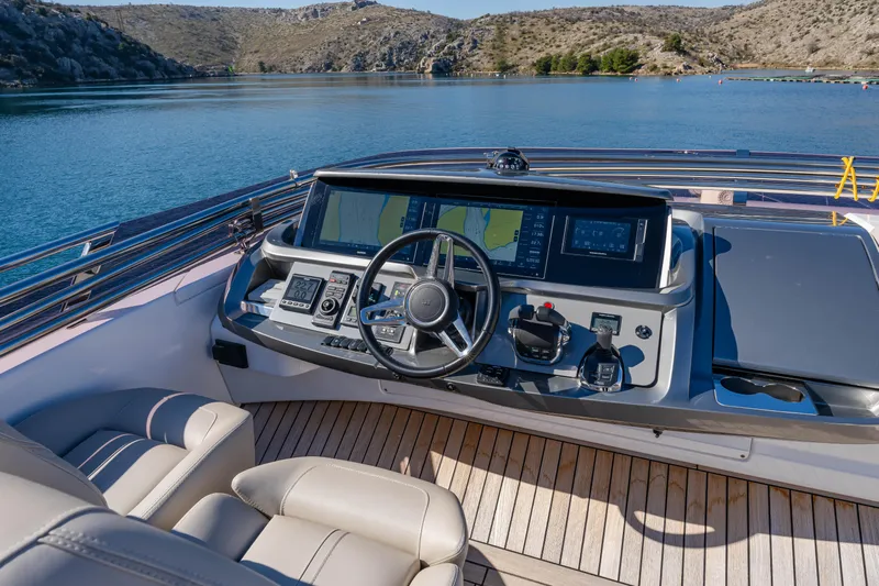 Whiskey Yacht Photos Pics Luxury yacht Princess F55 helm with modern controls, docked on serene water, 2021 model.