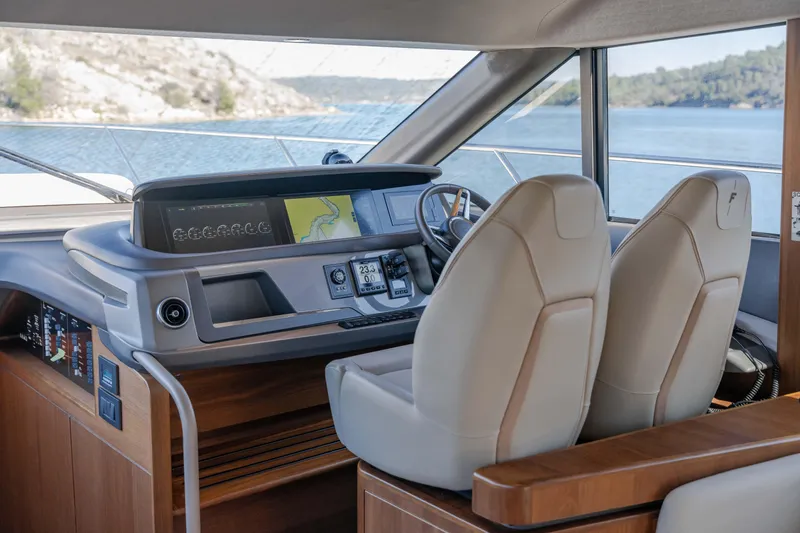 Whiskey Yacht Photos Pics Interior helm of 2021 Princess F55 yacht with modern navigation equipment and dual seating.