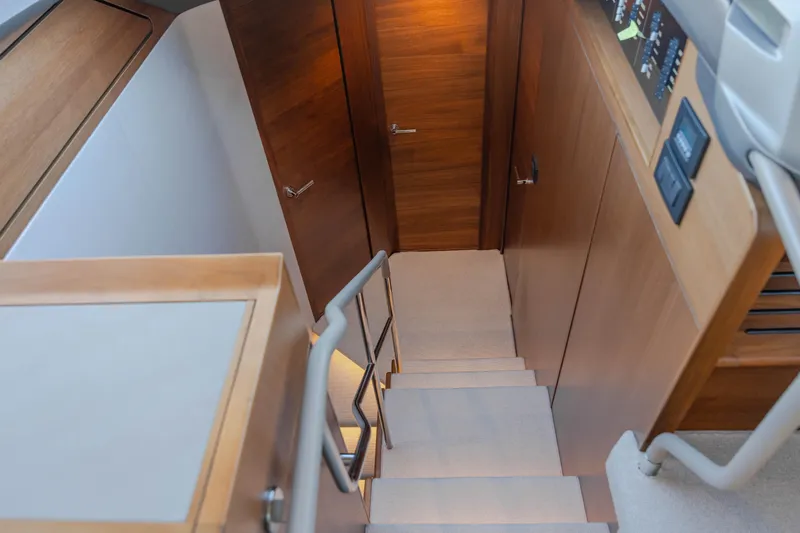Whiskey Yacht Photos Pics Staircase inside 2021 Princess F55 yacht, featuring wooden paneling and modern design.