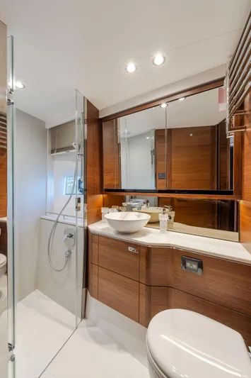 Whiskey Yacht Photos Pics Luxurious bathroom in 2021 Princess F55 yacht with modern fixtures and elegant wood accents.