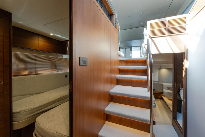 Whiskey Yacht Photos Pics Interior of 2021 Princess F55 yacht with wooden stairs and cozy seating area.