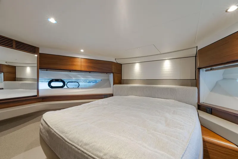 Whiskey Yacht Photos Pics Luxurious cabin interior of 2021 Princess F55 yacht with elegant wood accents and cozy bedding.