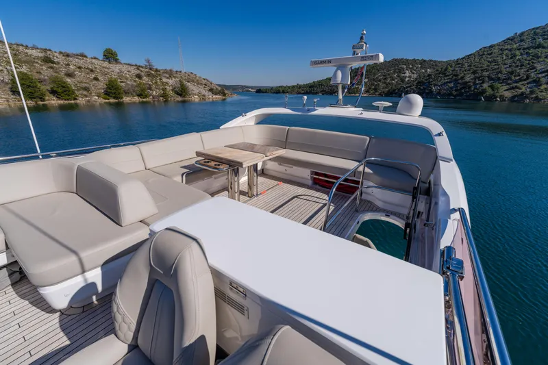 Whiskey Yacht Photos Pics Luxurious 2021 Princess F55 yacht deck with seating, cruising on a serene lake.