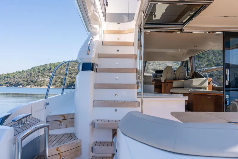 Whiskey Yacht Photos Pics Luxurious 2021 Princess F55 yacht interior with elegant seating and wooden stairs.
