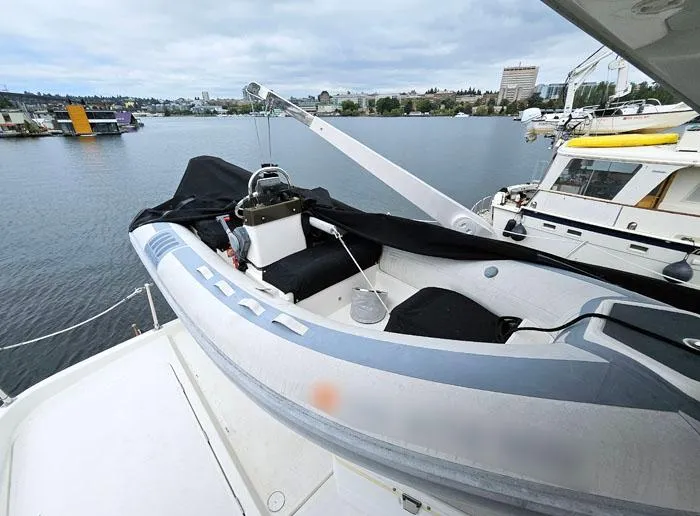  Yacht Photos Pics 2000 Bayliner 5288 Pilot House Motoryacht with dinghy on deck, docked at marina.