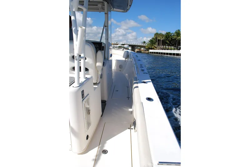Playin Hooky Yacht Photos Pics 2019 Cobia 344 Center Console boat cruising on a sunny day, near palm-lined shore.