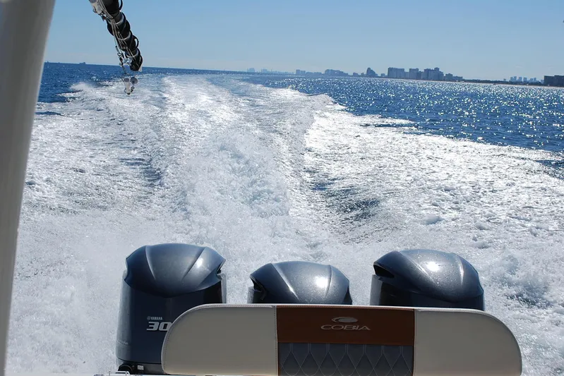 Playin Hooky Yacht Photos Pics 2019 Cobia 344 Center Console boat cruising on open water, leaving a wake behind.