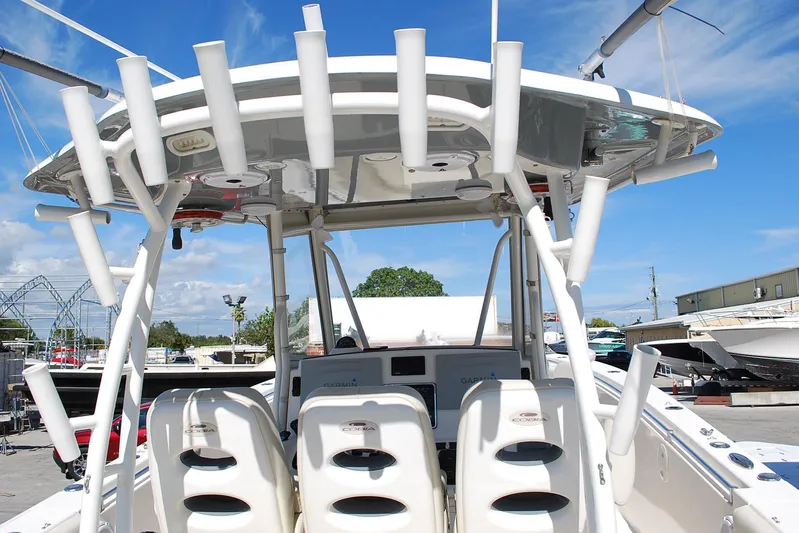 Playin Hooky Yacht Photos Pics 2019 Cobia 344 Center Console boat with rod holders and seating, docked under blue sky.