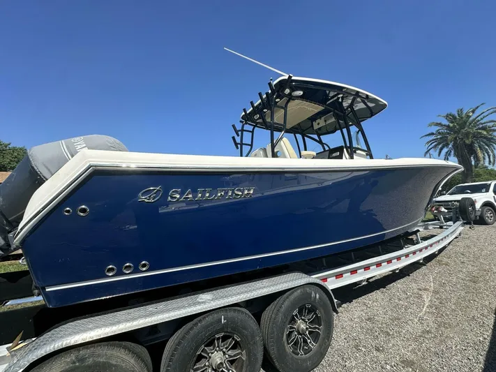  Yacht Photos Pics 2021 Sailfish 29 Center Console boat on trailer under clear blue sky.