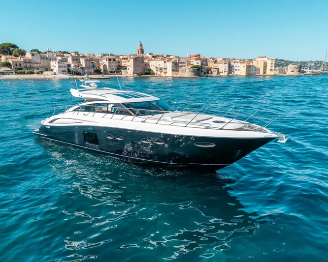  Yacht Photos Pics Luxury Princess V62 yacht cruising near coastal town, clear blue waters, sunny day, 2011 model.