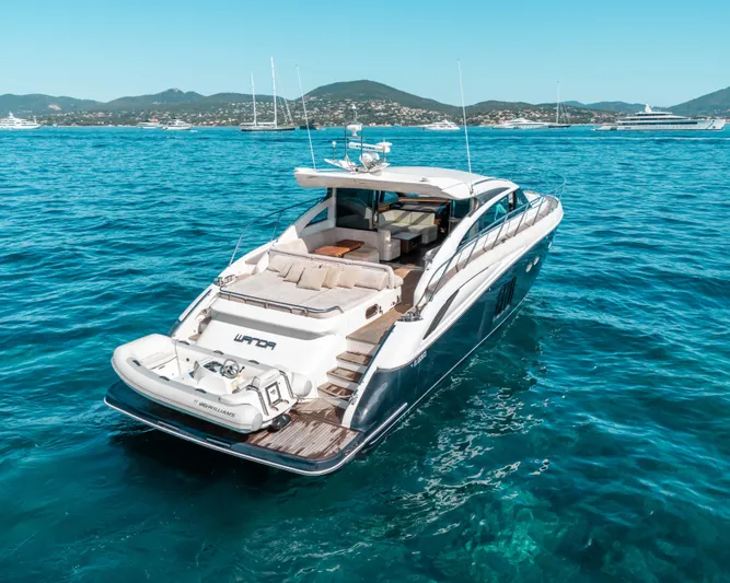  Yacht Photos Pics Luxury 2011 Princess V62 yacht on clear blue water, with scenic coastal backdrop.