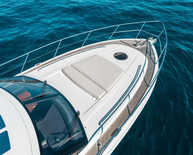  Yacht Photos Pics Luxury 2011 Princess V62 yacht on clear blue water, showcasing sleek design and sunbathing area.