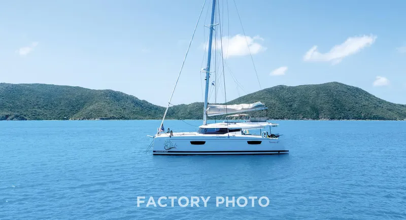 Bonova Yacht Photos Pics 2022 Fountaine Pajot Tanna 47 catamaran sailing in clear blue waters, scenic island backdrop.