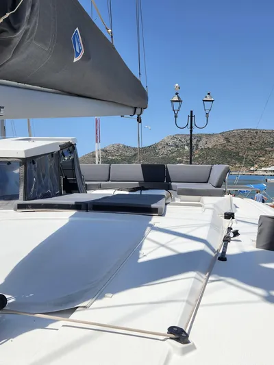 Bonova Yacht Photos Pics 2022 Fountaine Pajot Tanna 47 yacht deck with seating, scenic coastal backdrop.