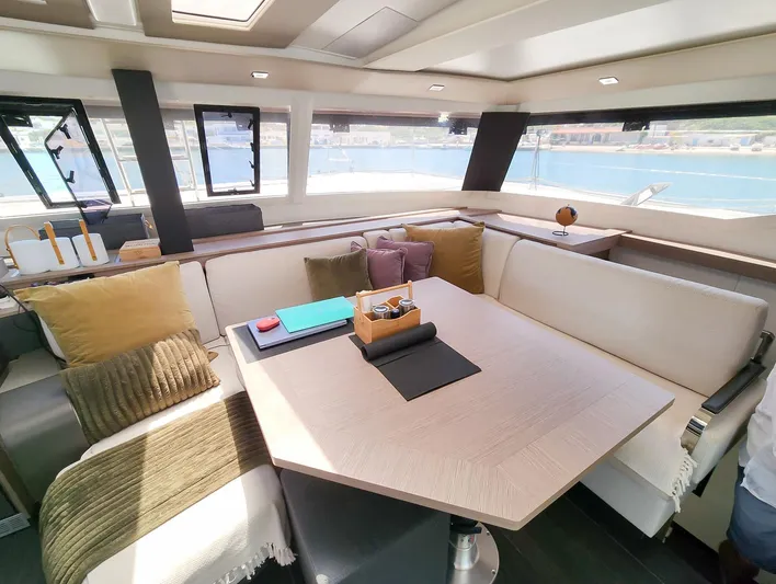 Bonova Yacht Photos Pics Luxurious interior of 2022 Fountaine Pajot Tanna 47 catamaran with elegant seating and panoramic windows.