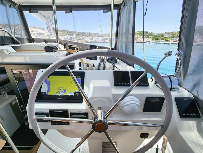 Bonova Yacht Photos Pics Helm of 2022 Fountaine Pajot Tanna 47 catamaran with navigation equipment and scenic marina view.