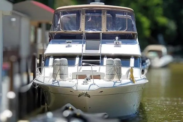 Basic Instinct Yacht Photos Pics 1995 Sea Ray 440 Express Bridge yacht docked on calm water.