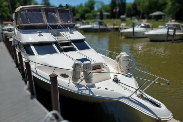 Basic Instinct Yacht Photos Pics 1995 Sea Ray 440 Express Bridge docked in a marina, sunny day.