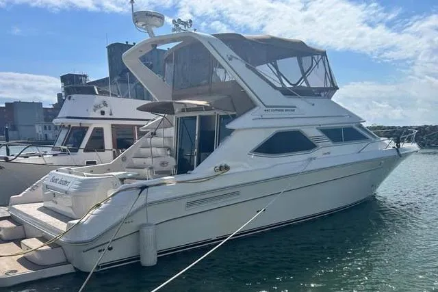 Basic Instinct Yacht Photos Pics 1995 Sea Ray 440 Express Bridge yacht docked in a marina under a clear sky.