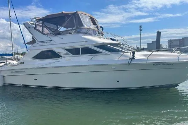 Basic Instinct Yacht Photos Pics 1995 Sea Ray 440 Express Bridge yacht docked in a marina under a clear blue sky.