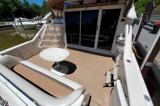 Basic Instinct Yacht Photos Pics 1995 Sea Ray 440 Express Bridge yacht deck with seating, table, and ladder.