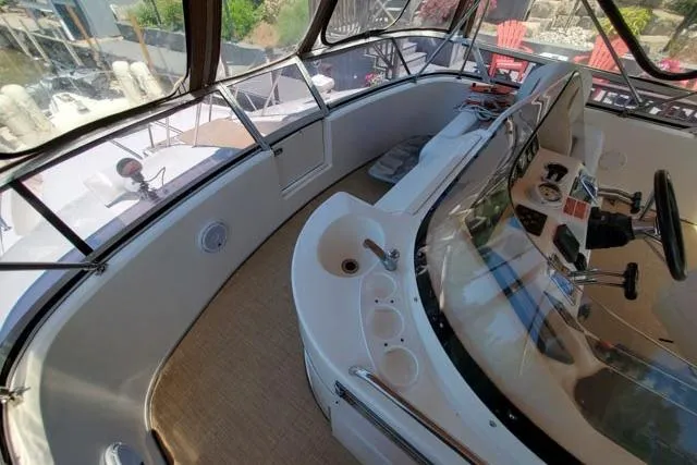 Basic Instinct Yacht Photos Pics 1995 Sea Ray 440 Express Bridge cockpit with steering wheel and control panel.