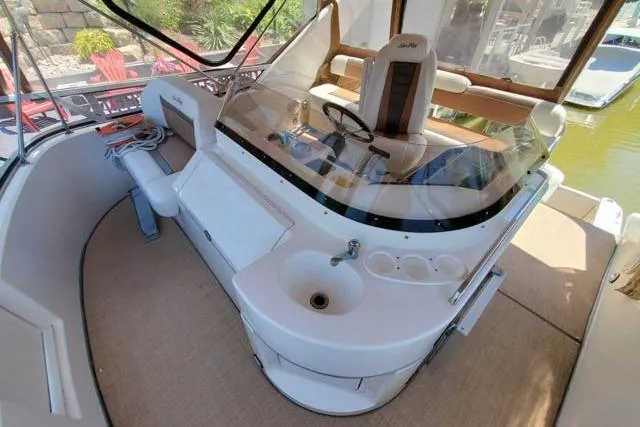 Basic Instinct Yacht Photos Pics 1995 Sea Ray 440 Express Bridge cockpit with helm, seating, and sink.