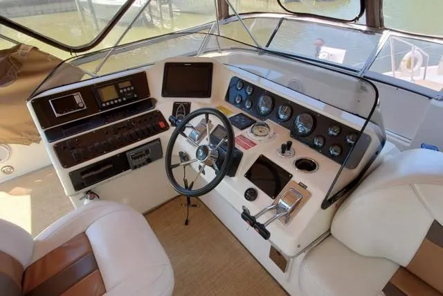 Basic Instinct Yacht Photos Pics 1995 Sea Ray 440 Express Bridge helm with steering wheel, gauges, and controls.