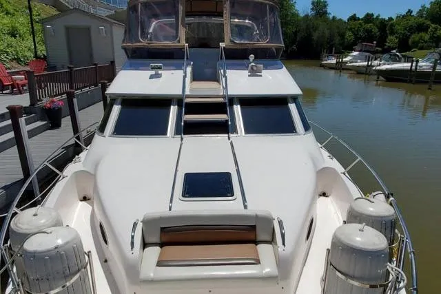 Basic Instinct Yacht Photos Pics 1995 Sea Ray 440 Express Bridge yacht docked by a serene waterfront.