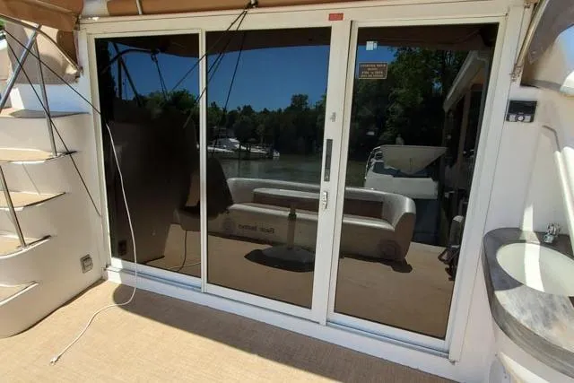 Basic Instinct Yacht Photos Pics 1995 Sea Ray 440 Express Bridge yacht with sliding glass doors and outdoor seating area.