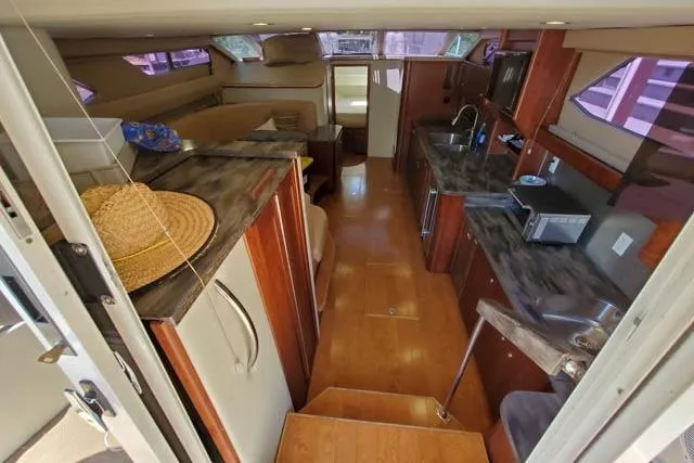 Basic Instinct Yacht Photos Pics Interior of 1995 Sea Ray 440 Express Bridge with modern kitchen and cozy seating area.