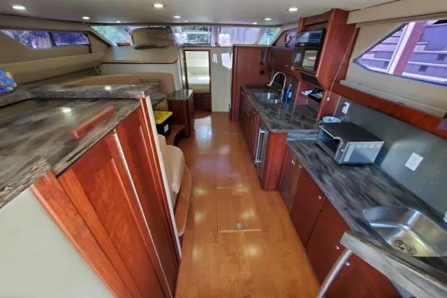 Basic Instinct Yacht Photos Pics Interior of 1995 Sea Ray 440 Express Bridge with modern kitchen and wood finishes.