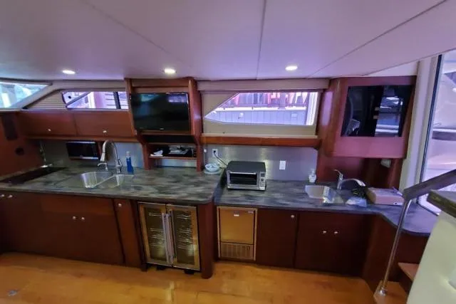 Basic Instinct Yacht Photos Pics 1995 Sea Ray 440 Express Bridge interior kitchen with modern appliances and wooden cabinetry.