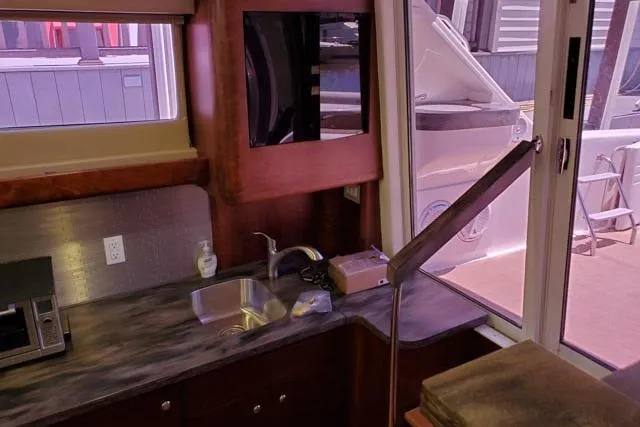 Basic Instinct Yacht Photos Pics Interior of 1995 Sea Ray 440 Express Bridge with kitchenette and outdoor view.