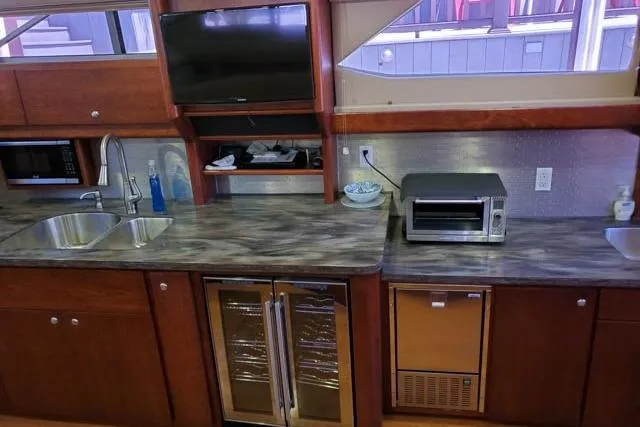 Basic Instinct Yacht Photos Pics 1995 Sea Ray 440 Express Bridge kitchen with modern appliances and wood cabinetry.