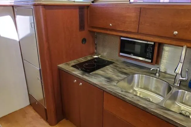 Basic Instinct Yacht Photos Pics 1995 Sea Ray 440 Express Bridge kitchen with stove, microwave, and dual sink.
