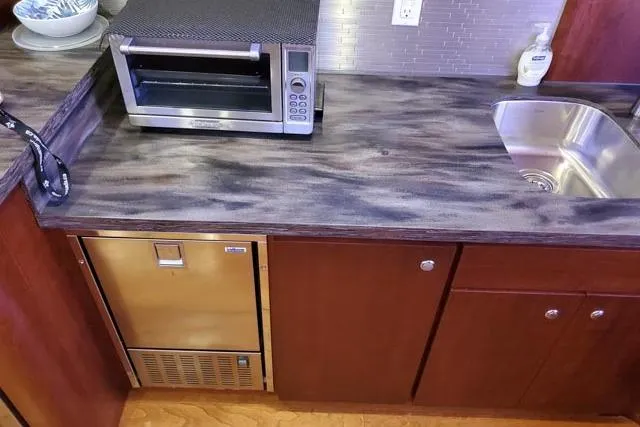 Basic Instinct Yacht Photos Pics Kitchen area of a 1995 Sea Ray 440 Express Bridge with countertop, sink, and toaster oven.