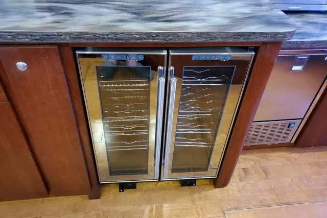Basic Instinct Yacht Photos Pics Built-in wine coolers on 1995 Sea Ray 440 Express Bridge yacht, featuring dual glass doors.