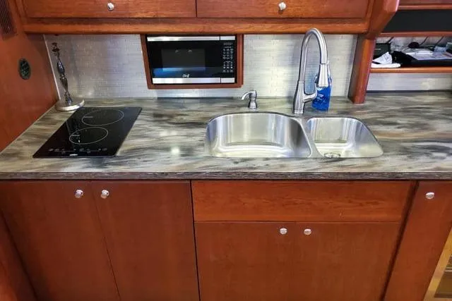 Basic Instinct Yacht Photos Pics 1995 Sea Ray 440 Express Bridge kitchen with modern sink, stove, and microwave.