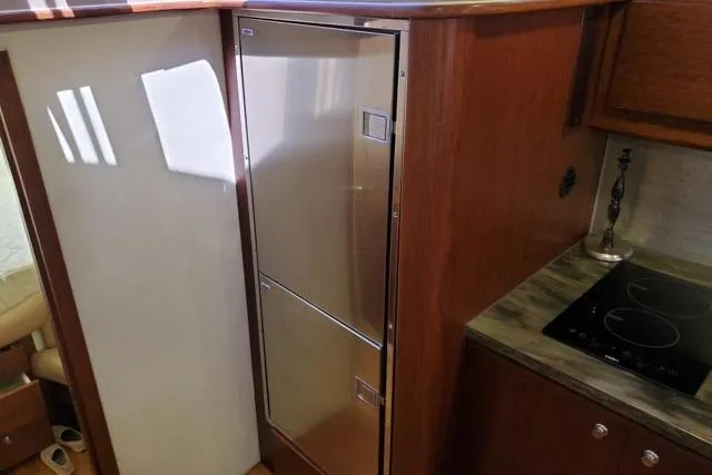 Basic Instinct Yacht Photos Pics 1995 Sea Ray 440 Express Bridge kitchen with stainless steel fridge and electric cooktop.