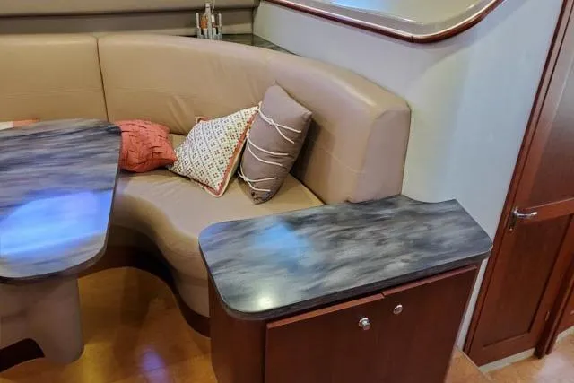 Basic Instinct Yacht Photos Pics Interior of 1995 Sea Ray 440 Express Bridge with cushioned seating and wooden cabinetry.