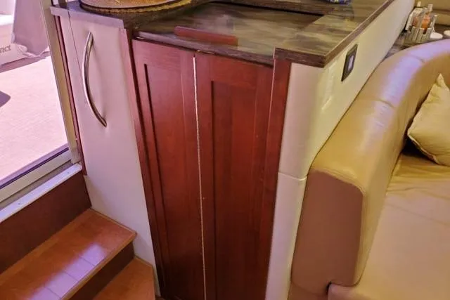 Basic Instinct Yacht Photos Pics 1995 Sea Ray 440 Express Bridge interior with wooden cabinetry and beige seating.