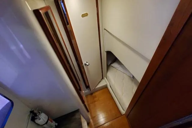 Basic Instinct Yacht Photos Pics 1995 Sea Ray 440 Express Bridge cabin interior with wooden flooring and compact bed.