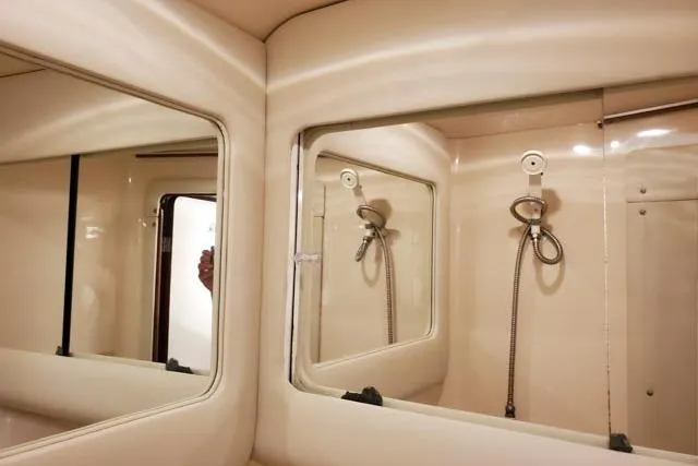 Basic Instinct Yacht Photos Pics Interior of 1995 Sea Ray 440 Express Bridge, featuring mirrored bathroom with shower fixtures.